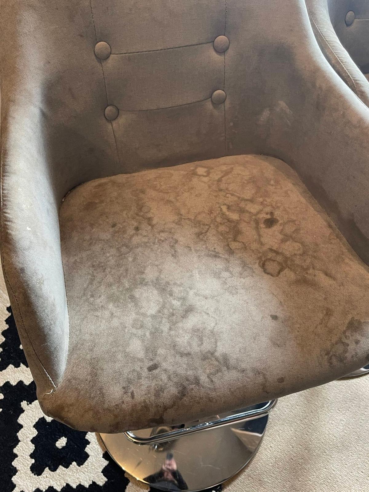 Stained armchair awaiting professional upholstery treatment