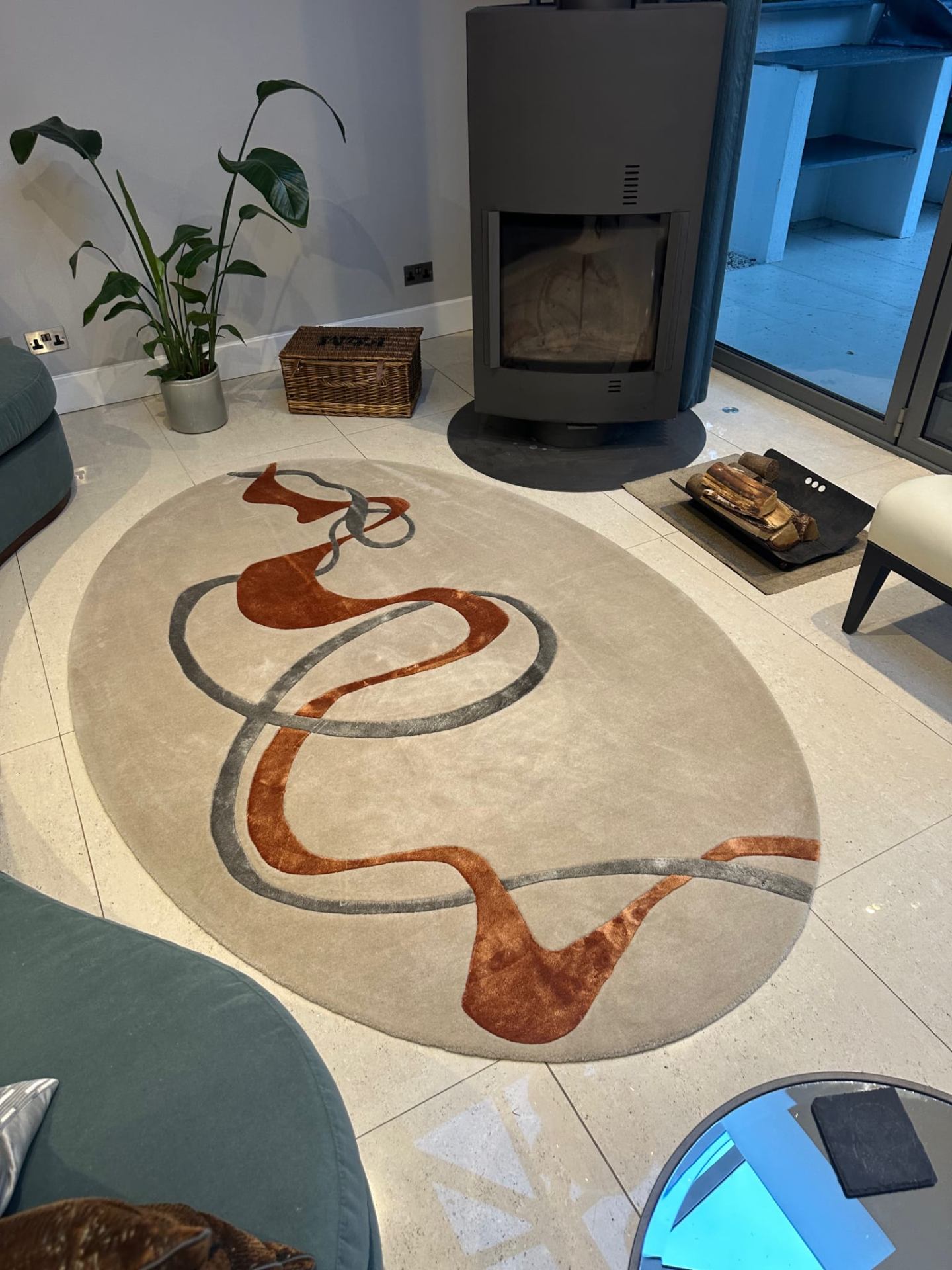 Designer oval rug with abstract pattern professionally cleaned in modern living room